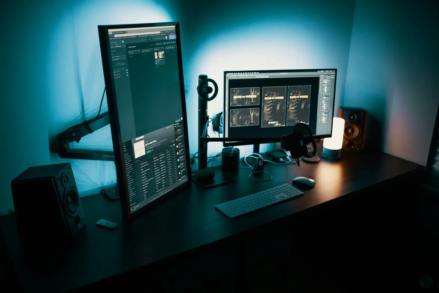 Um quarto escuro com uma mesa de madeira e dois monitores de computador onde está sendo projetado um site.